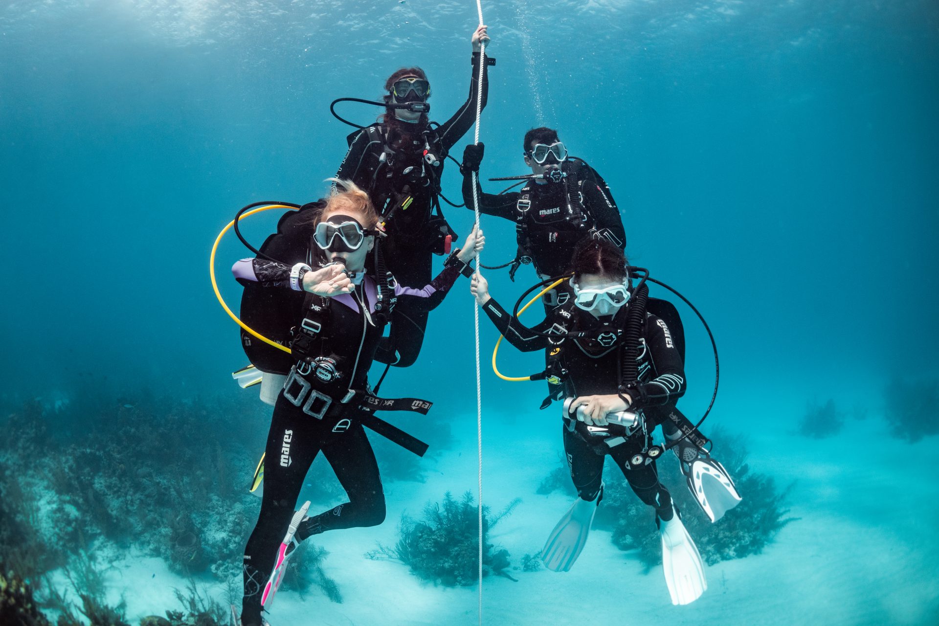 Scuba students descending a controlled descent line during their Open Water training course